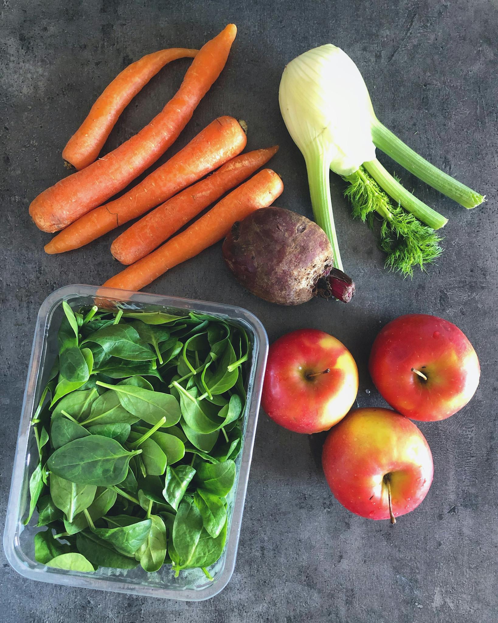 Colorful arrangement of fresh fruits and vegetables on dark background.